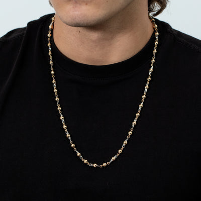 Esta elegante pieza, hecha a mano por expertos artesanos, es un collar de oro laminado de 18K con bolas laminadas doradas de 6mm y 65 cm de largo complementado con pinos de acero 316L con técnica de alambrismo.