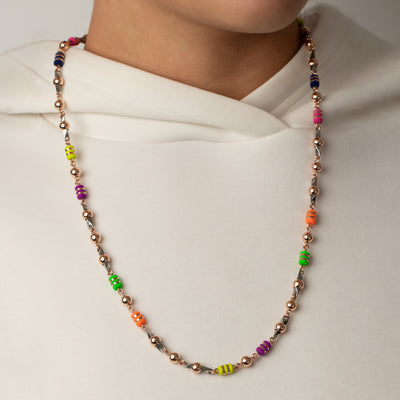 Collar exclusivo the beads, tipo pin. Elaborado con oro laminado 18k&nbsp; bolas&nbsp; 6mm Rosadas las cuales se le hace técnica de alambrismo artesanal y también se incrustan en pin de acero de joyería 316L, se acompaña todo esto con barriles de neoprenos argollados con cinta laminada.