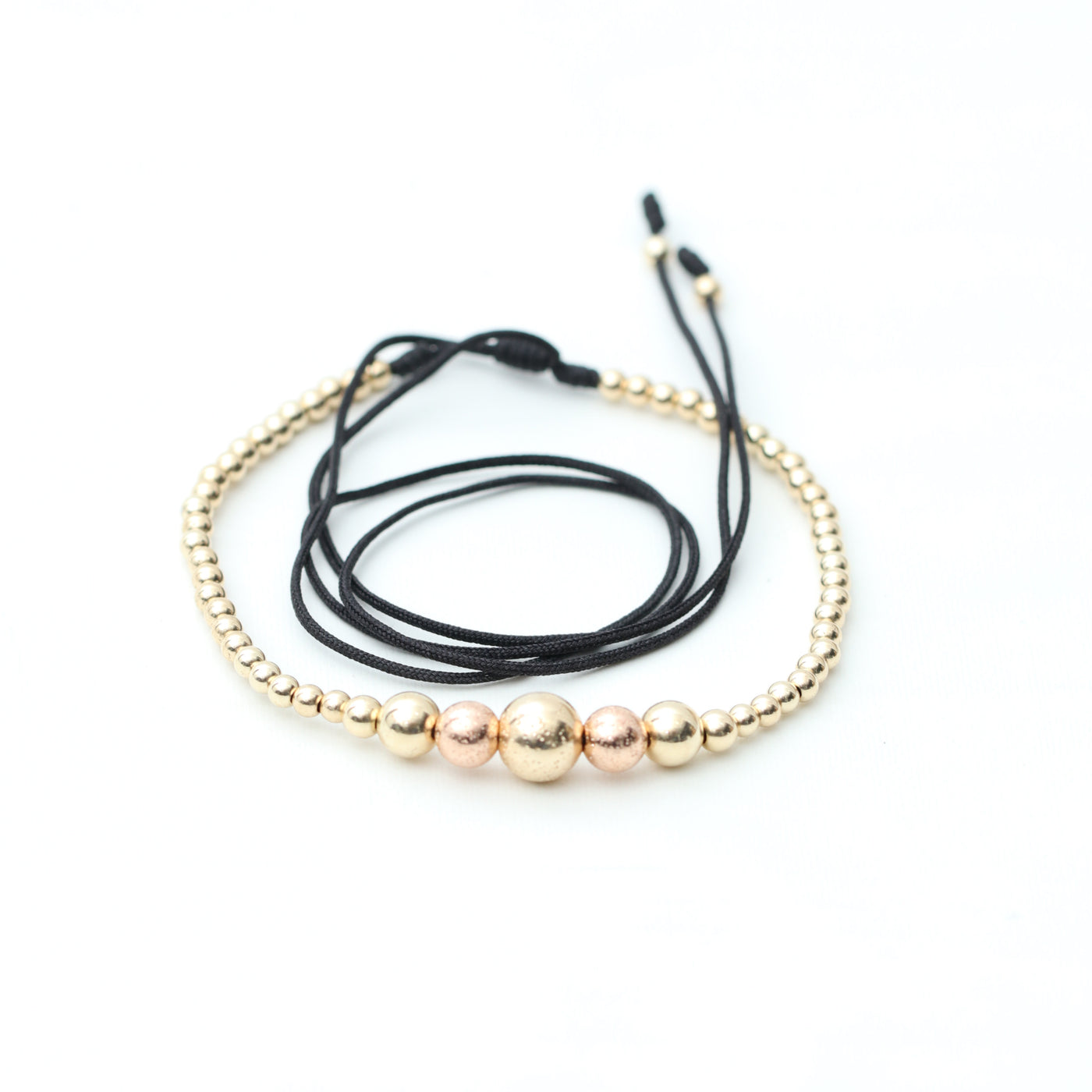 Gargantilla en oro laminado 18k tejida en hilo sintético, con B8MM dorado diamantado, B6MM rosado diamantado y plateada y B3MM dorada, elaborada por expertos artesanos en el tejido macramé.