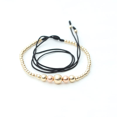 Gargantilla en oro laminado 18k tejida en hilo sintético, con B8MM dorado diamantado, B6MM rosado diamantado y plateada y B3MM dorada, elaborada por expertos artesanos en el tejido macramé.