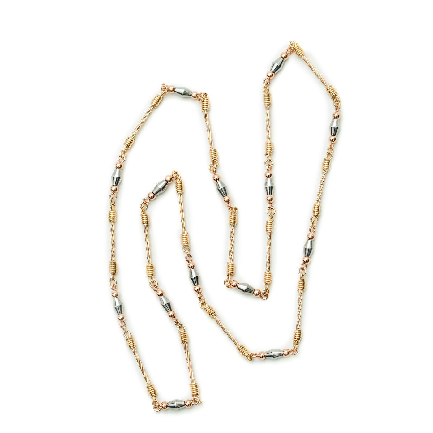 Con un acabado en oro laminado dorado, rosado y acero de primera calidad 316L, esta joya artesanal estilo rústico se crea mediante una técnica de alambrismo de alta joyería. Esto le da un estético toque con los entorches Dorados,Separadores Plateados y las bolas rosadas. Inspirado en la cultura griega, el collar es a 62 cm de longitud e incorpora detalles de las columnas Romanas